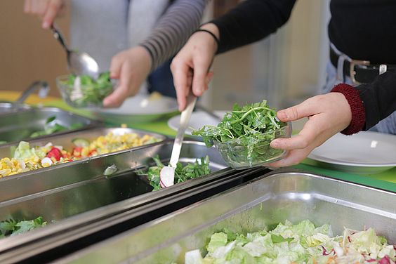 Ein Kind bedient sich am Salatbuffet