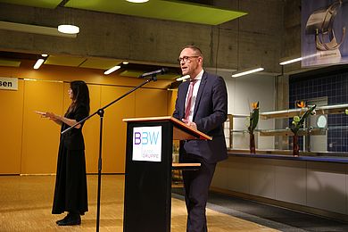 Hauptgeschäftsführer Tobias Schmidt steht am Redner*innenpult und hält eine Rede