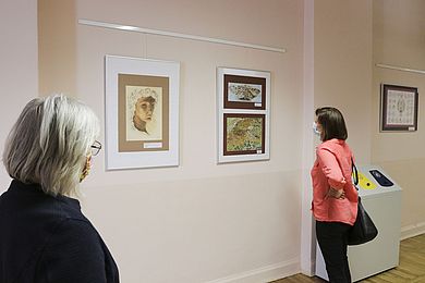 Besucher betrachten Bilder in der Ausstellung