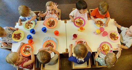 Kindergartenkinder essen zu Mittag.