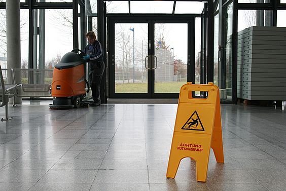 Bodenreinigung mit Warnhinweis-Schild